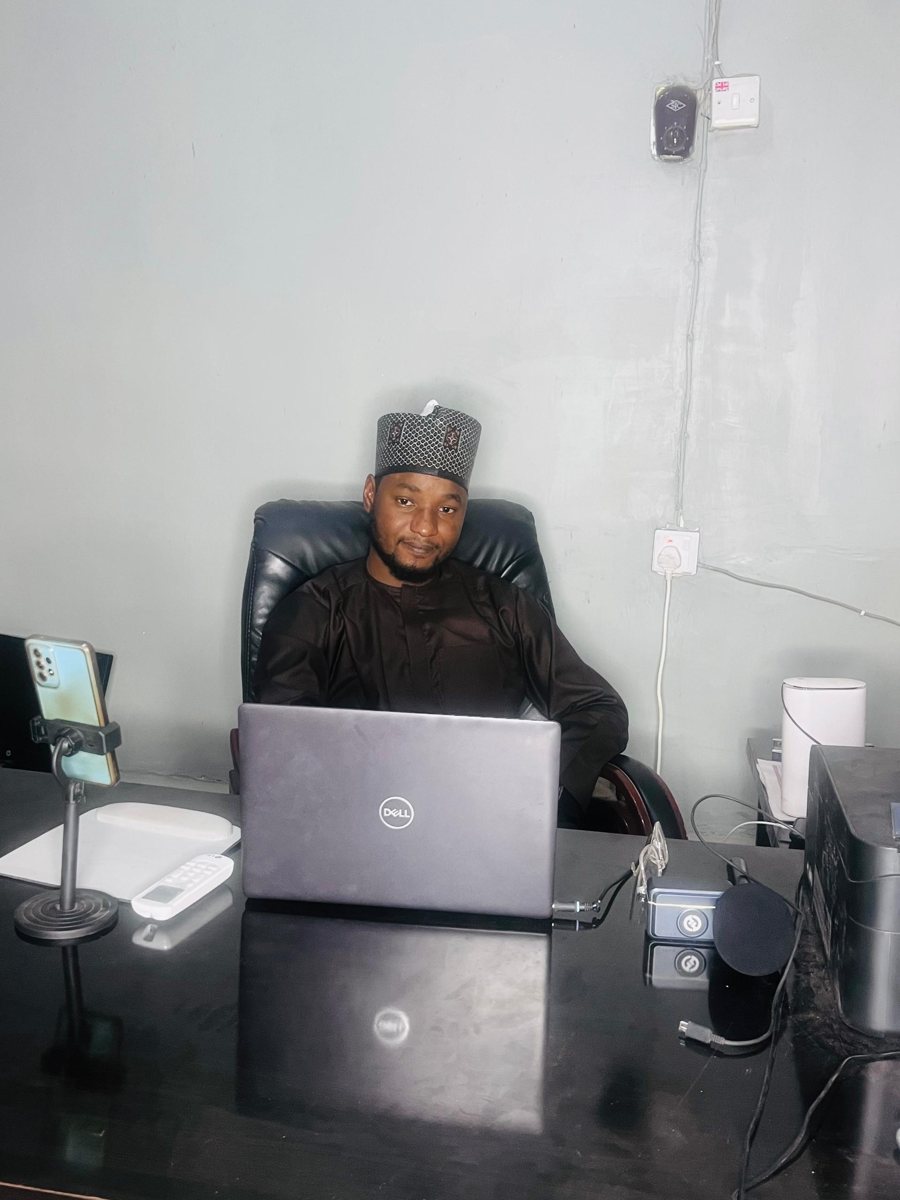 Haruna Abdullahi Mamuda working at his desk at Elharoon Academy